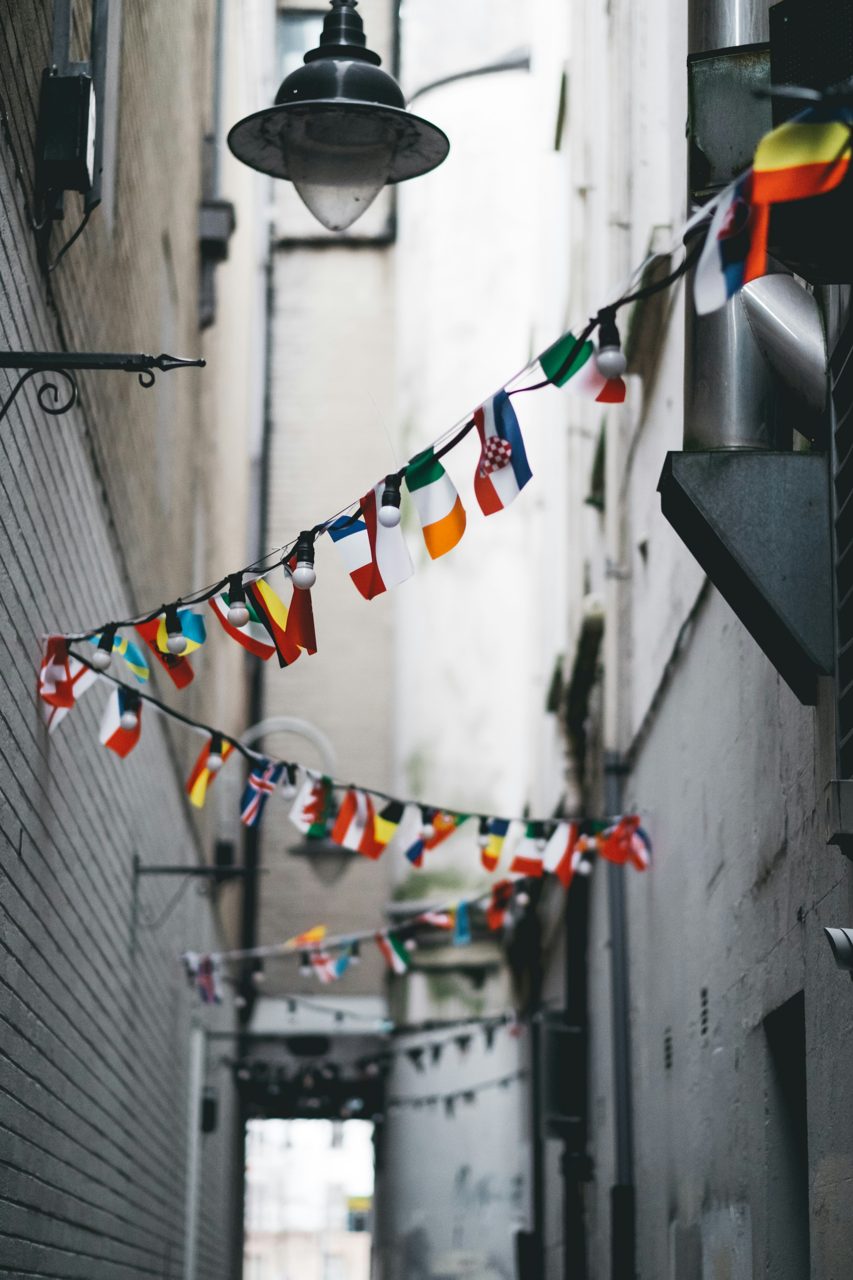 Strings of international flags from many nations hung across a city street